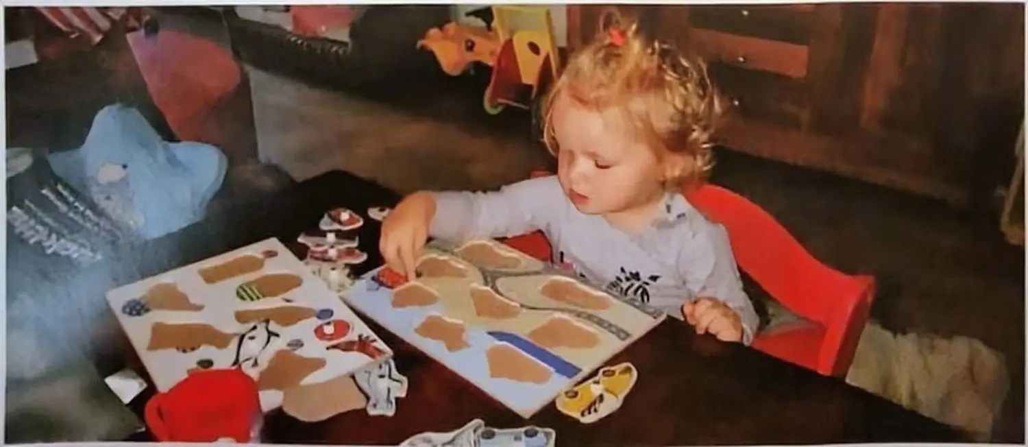 Praxis für Logopädie Marina Unger – kleines Mädchen spielt mit Puzzles im Therapieraum